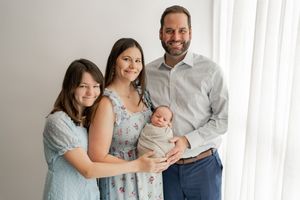 A series of family portraits in matching blue and grey outfits posing together in front of a white background.