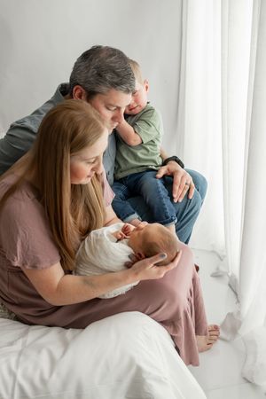 Intimate lifestyle photography session with couple in casual attire on white background.