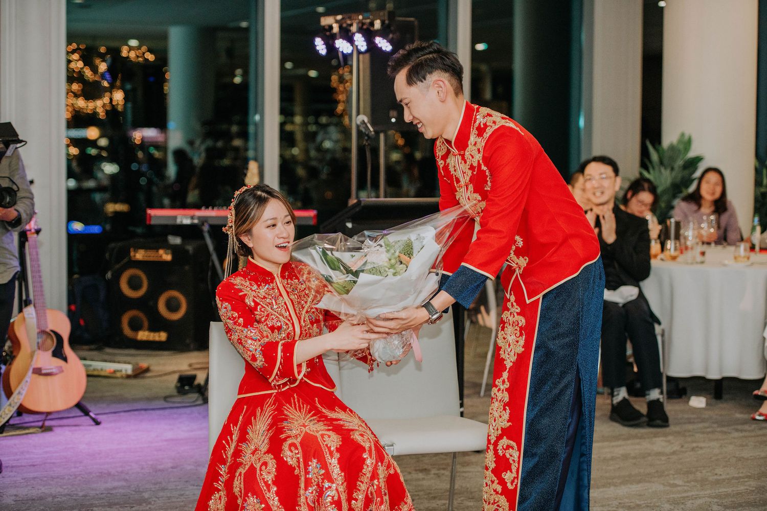 Traditional Chinese wedding ceremony with couple in red outfits dancing at reception.