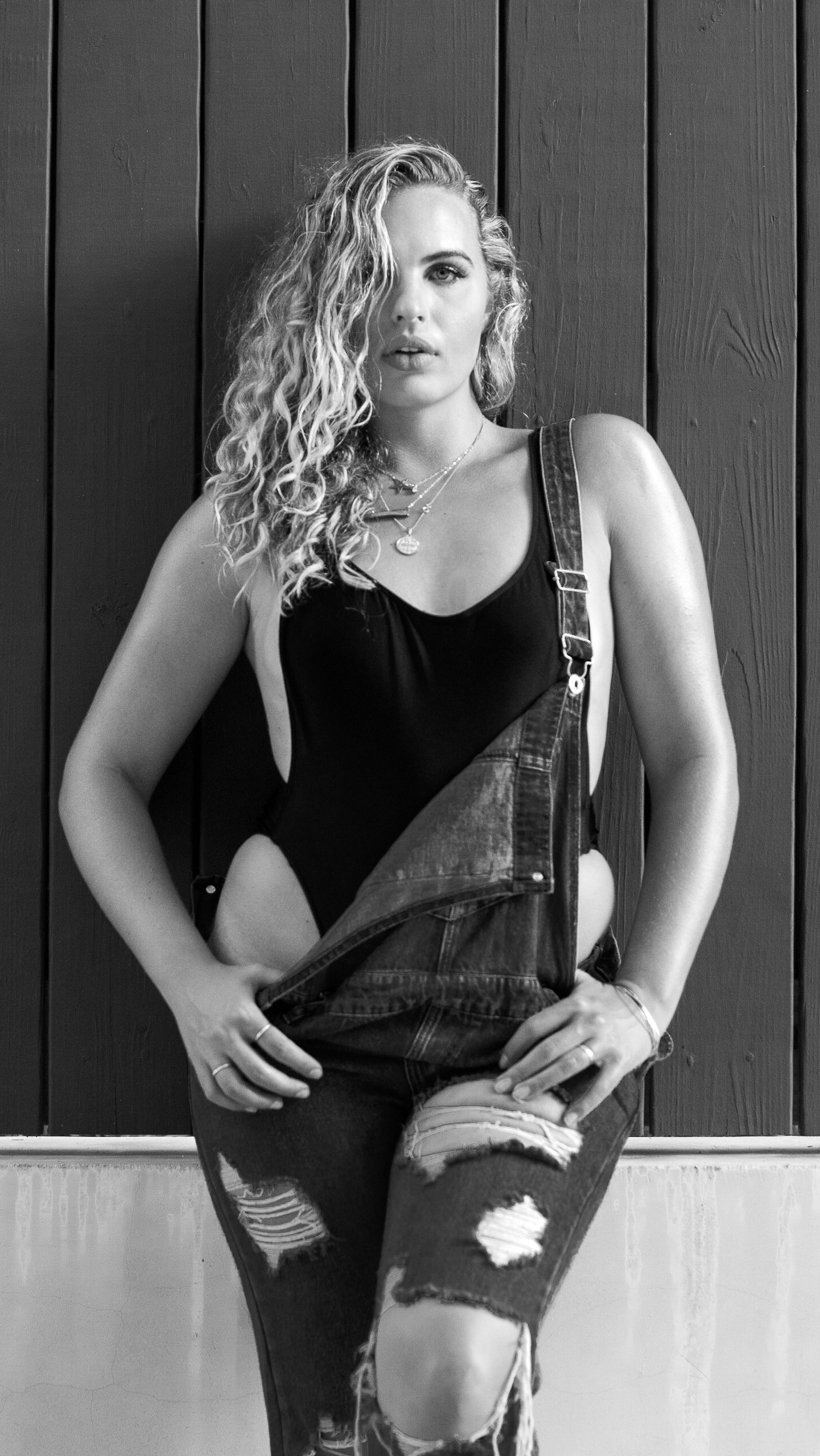 Artistic black and white portrait series against dark wooden wall background.