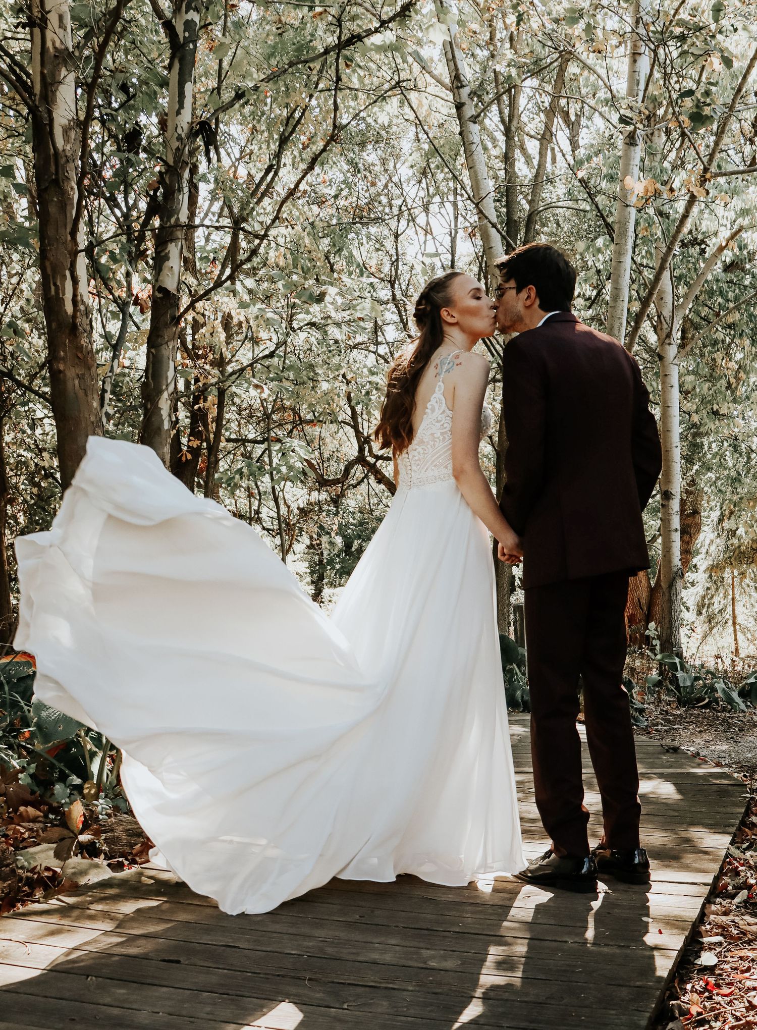 Romantic wedding photos in sequence showing couple with flowing white dress in wooded setting.