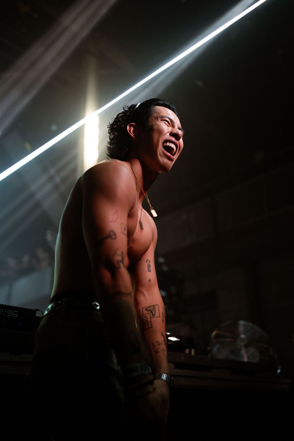 Dramatic black and white performance photos showing a shirtless performer under dramatic stage lighting.