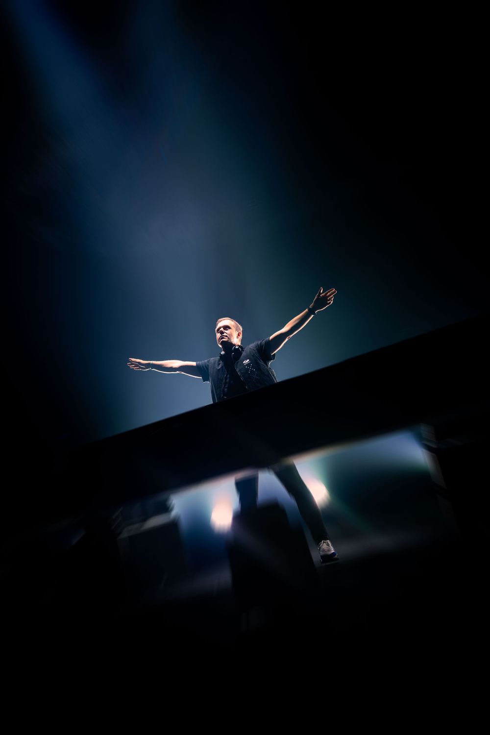 Silhouetted figure performing on stage with dramatic backlighting creating a dynamic pose.