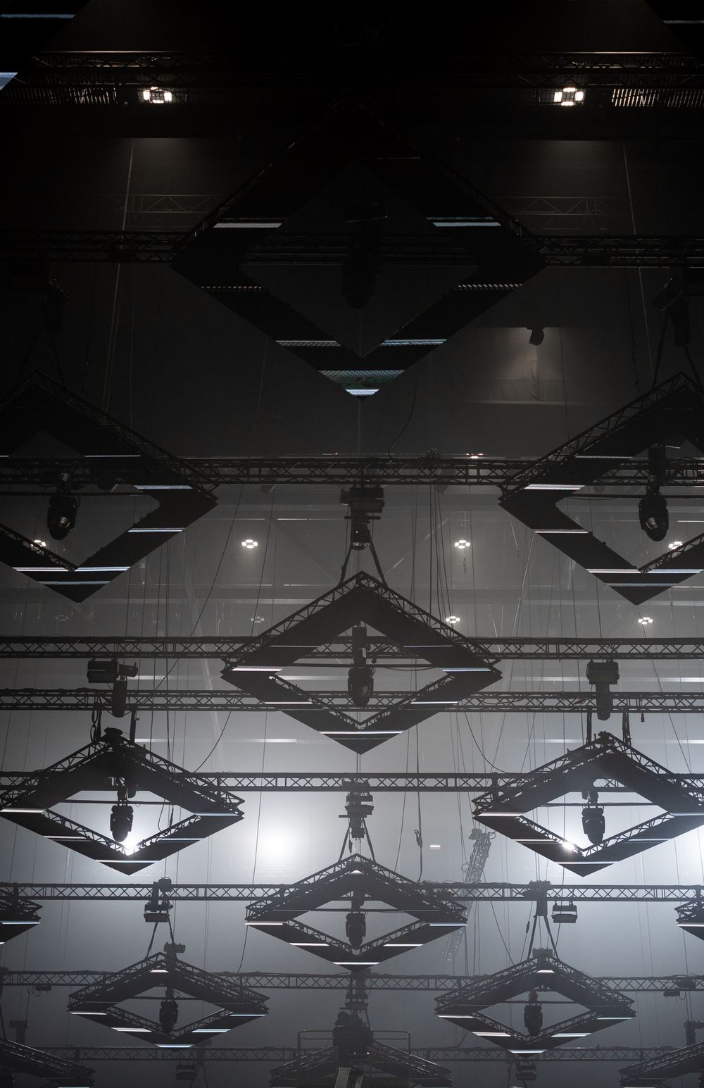 Industrial ceiling with geometric light fixtures in a symmetrical pattern.