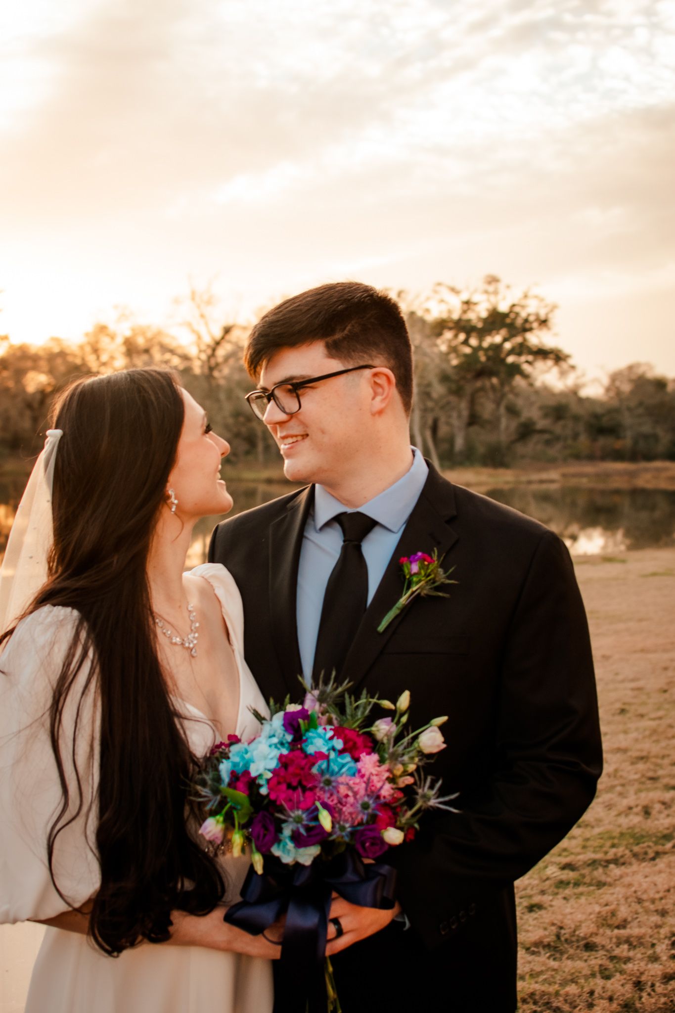 A sunset wedding portrait with the couple sharing a joyful moment outdoors.