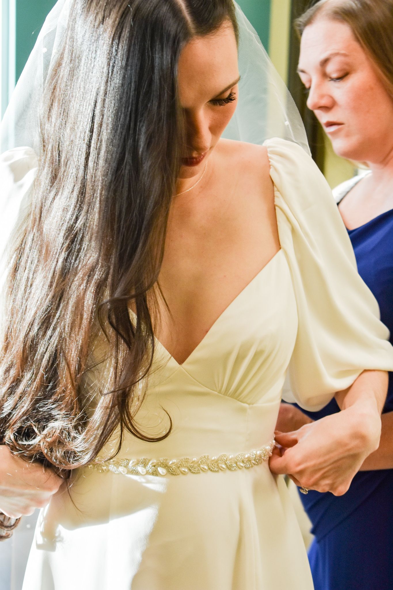 Wedding dress fitting showing details of the waistline and v-neck bodice.
