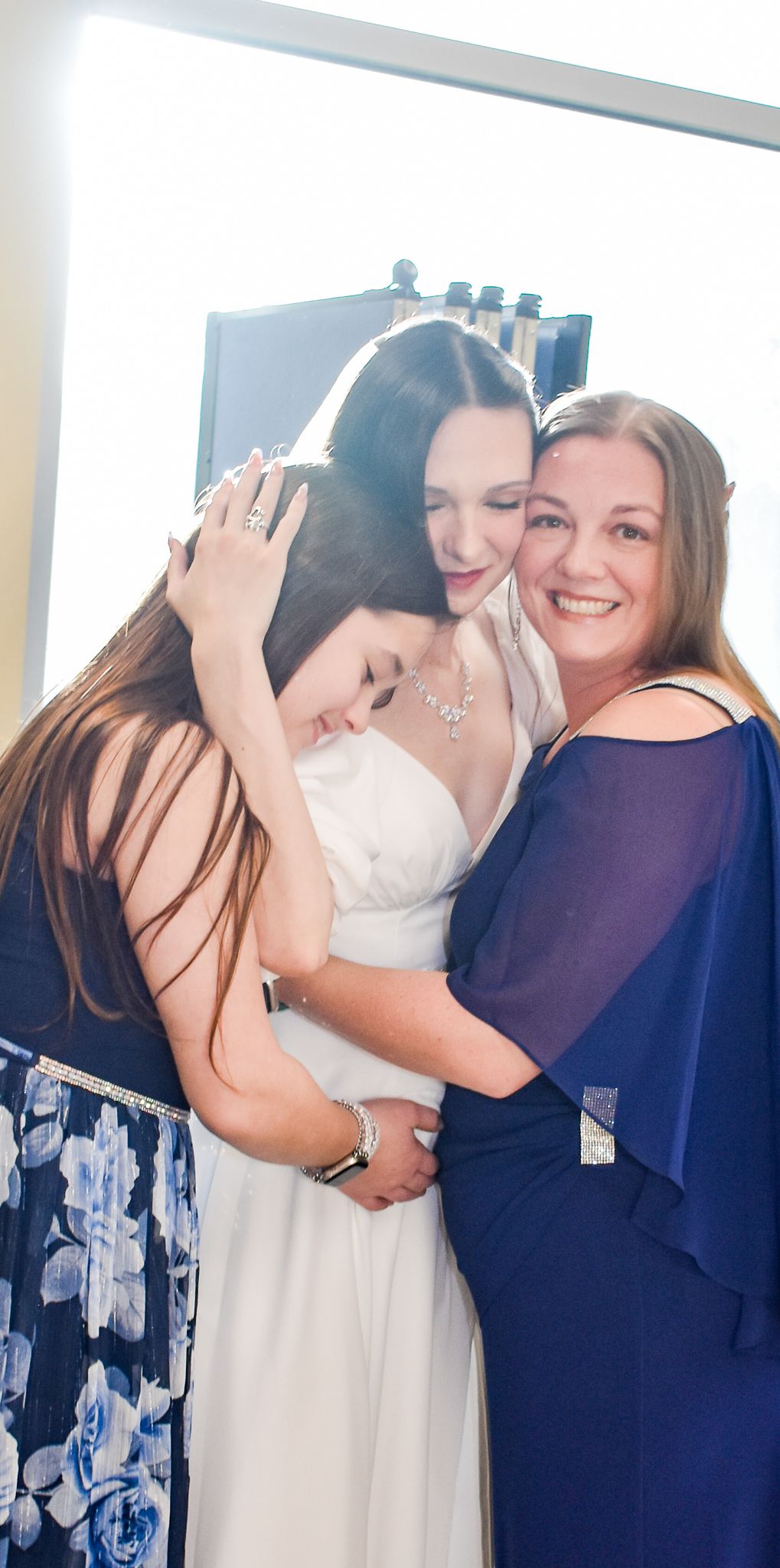 Emotional moment shared during wedding preparations in a bright room.