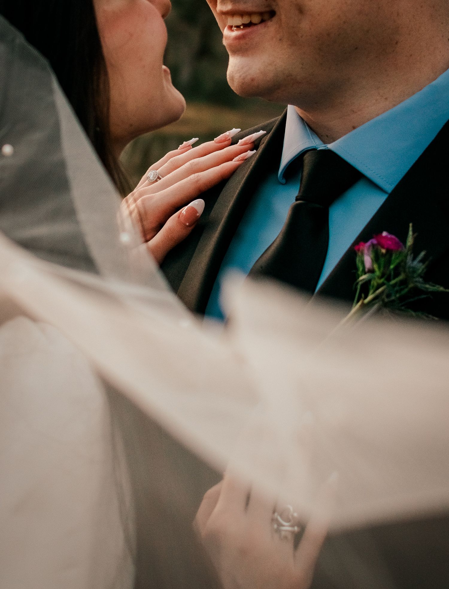 A tender moment between newlyweds with flowing veil movement in soft lighting.