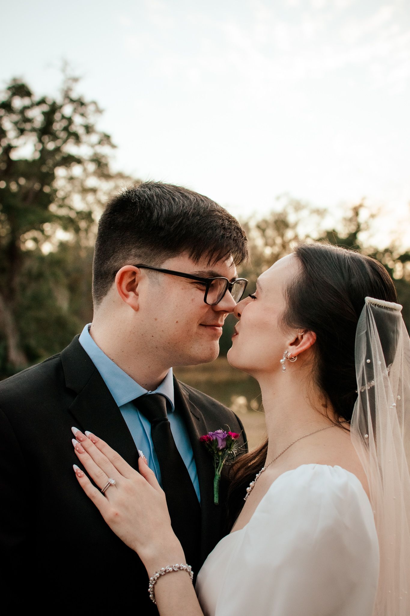 Intimate wedding portrait of couple sharing tender moment at sunset.