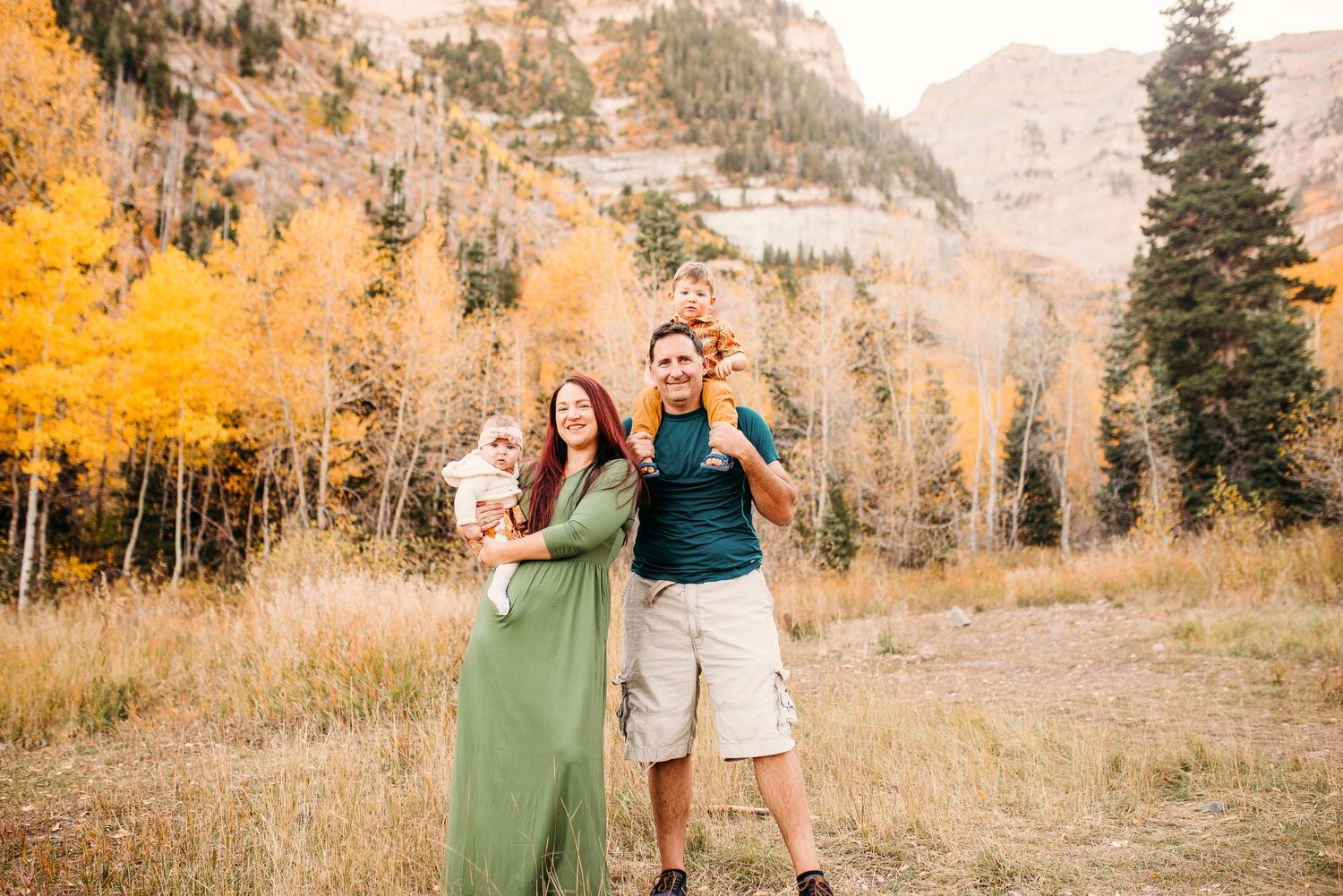 Couple enjoying scenic mountain view surrounded by golden aspen trees in fall.