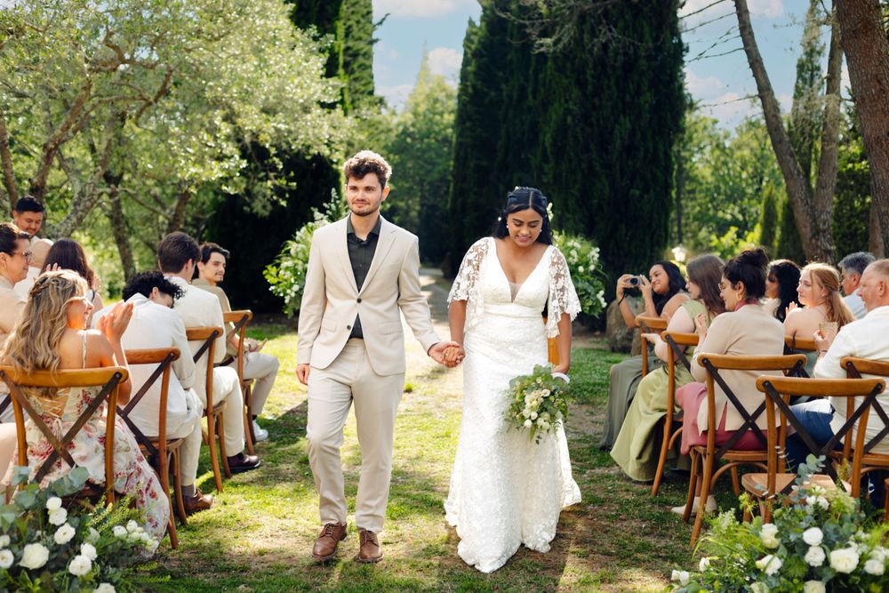Garden wedding ceremony setup with rustic wooden chairs and natural decorations.