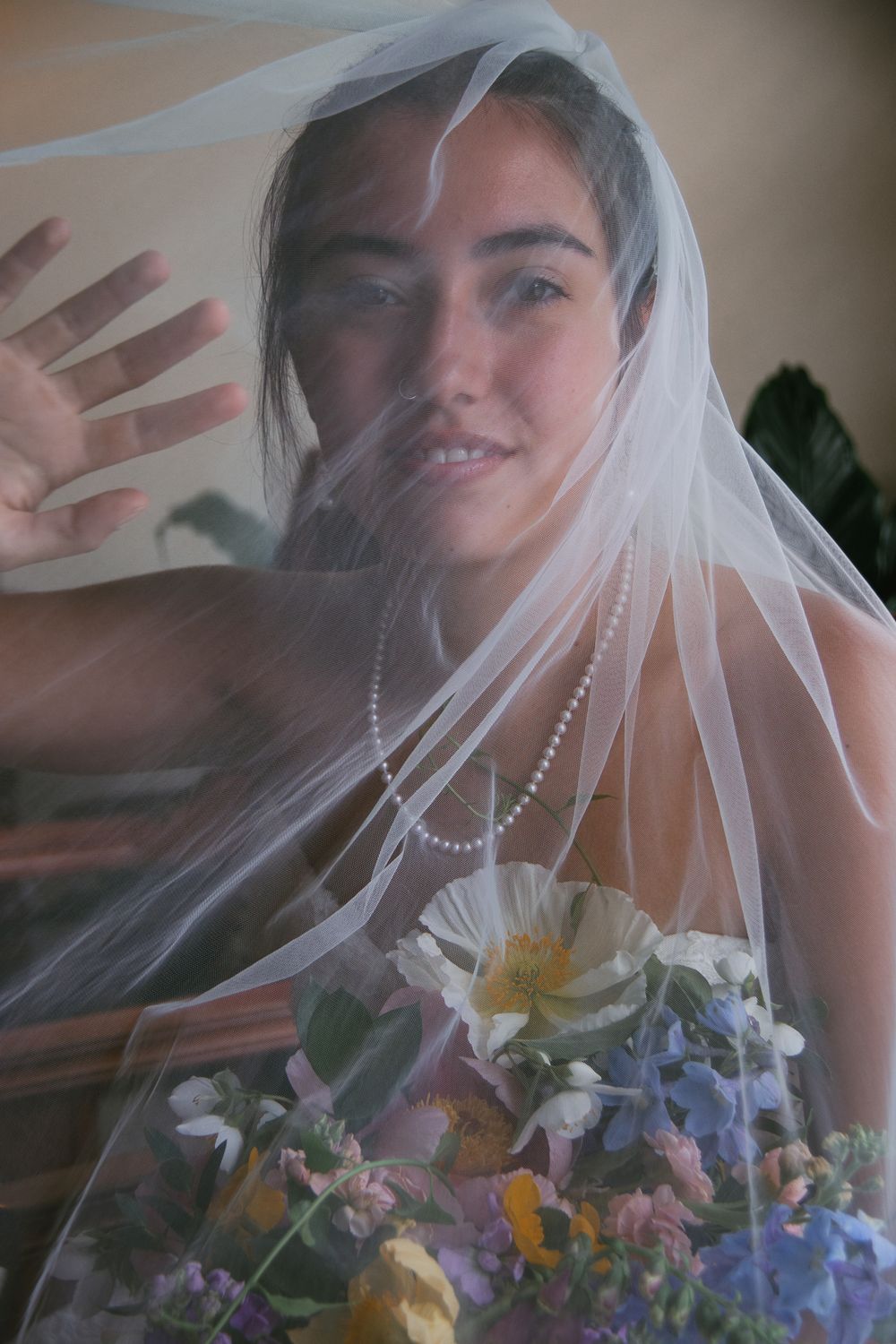 Romantic bridal portrait through sheer veil with colorful spring bouquet. Historic venue wedding photographer North Carolina