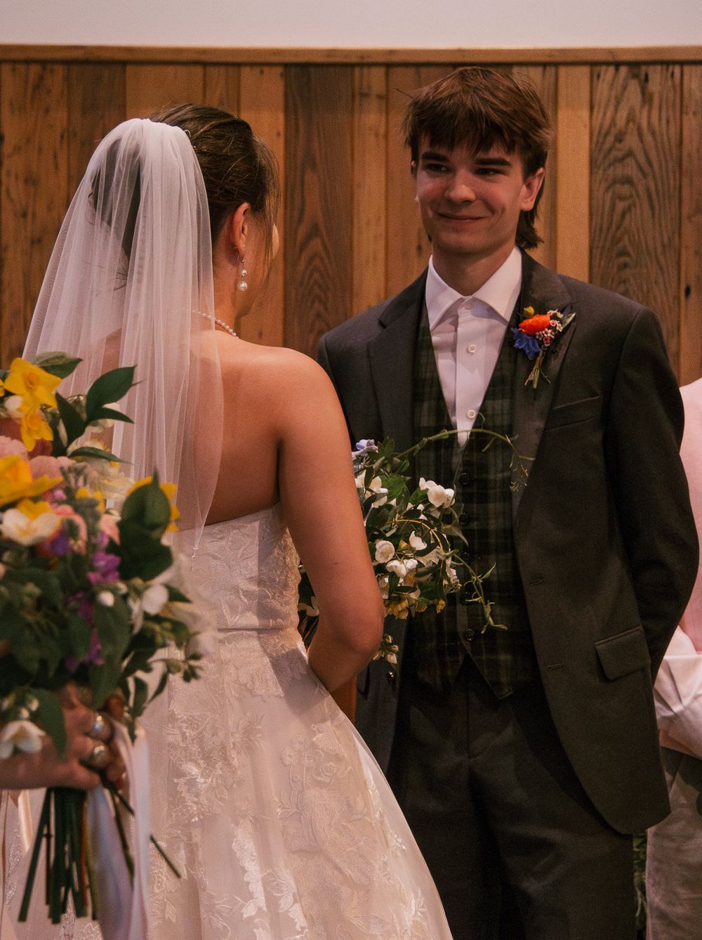 Wedding ceremony scene with bride in white dress and groom in dark suit holding bouquets. Historic venue wedding photographer North Carolina