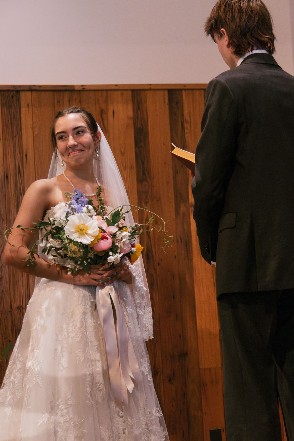 Candid wedding ceremony moments with bride in lace dress holding colorful bouquet. Historic venue wedding photographer North Carolina