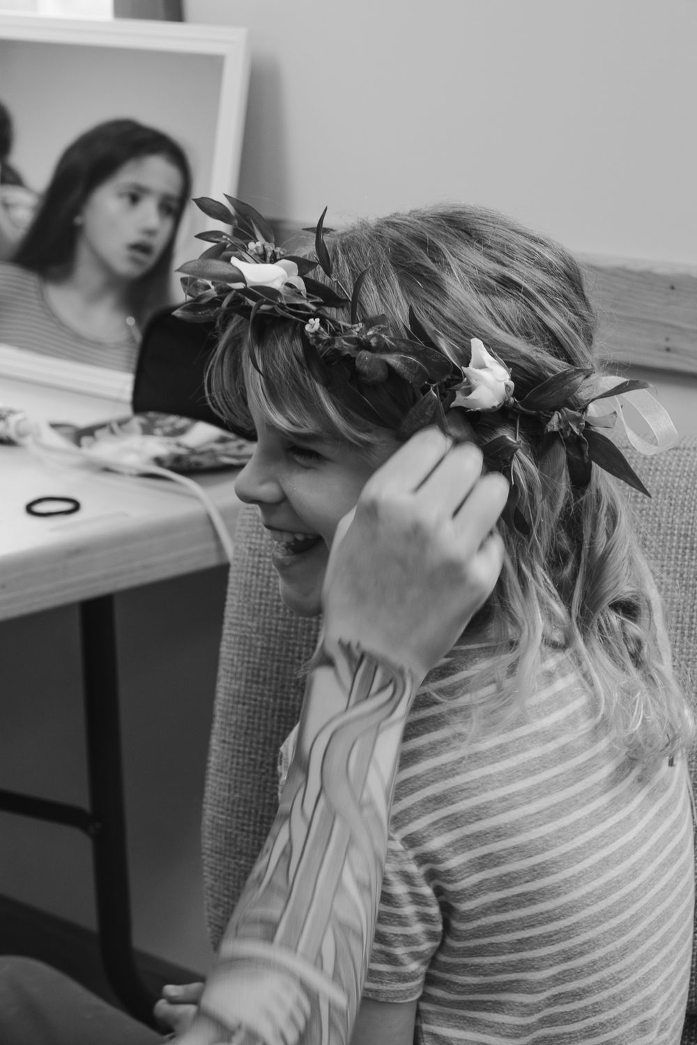 Person getting hair styled with floral accessories in black and white. Historic venue wedding photographer North Carolina