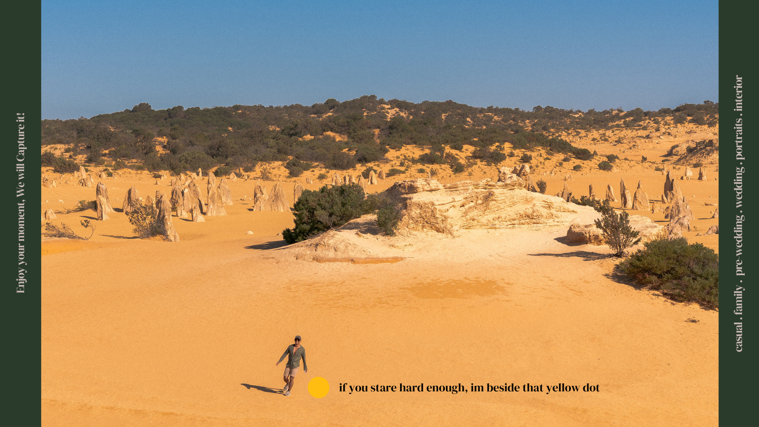 Person walking through vast golden sand dunes under clear blue sky.