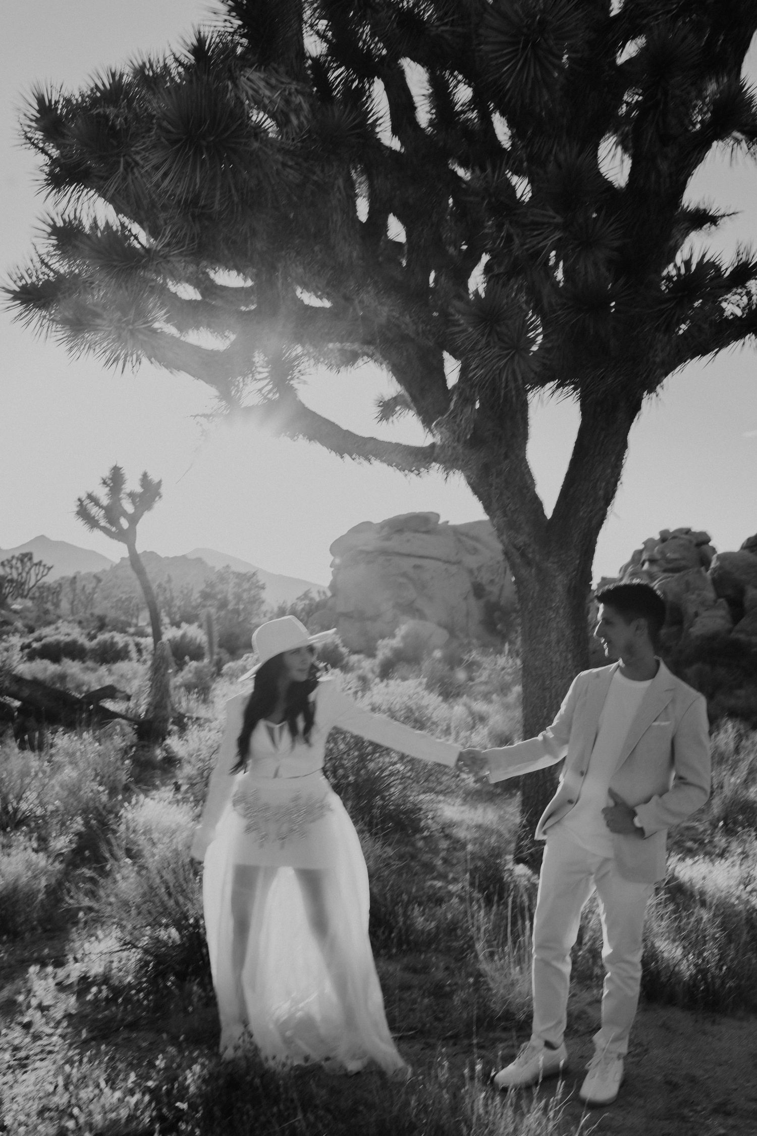 Desert wedding photoshoot with Joshua trees and rock formations in black and white.
