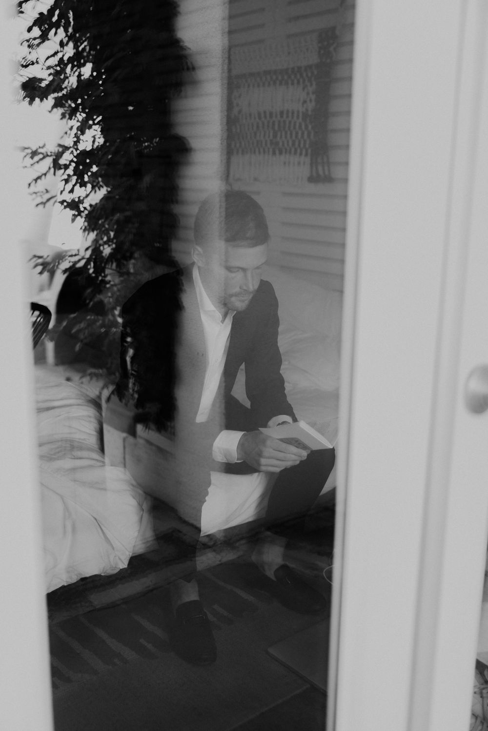 Black and white artistic photo through window reflection creating moody atmosphere.