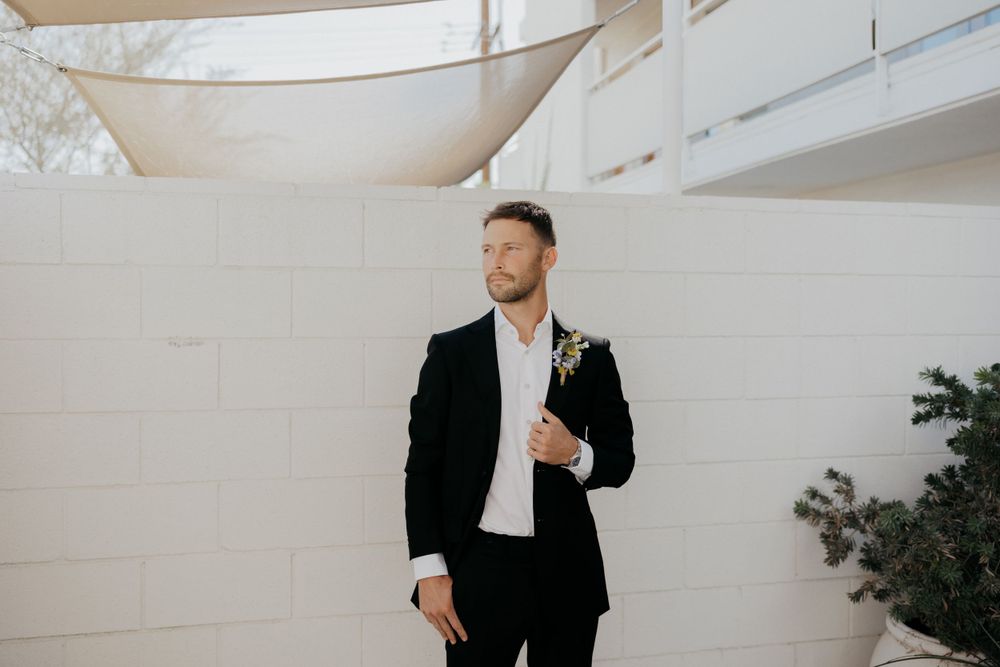 Wedding attire photo featuring modern minimalist outdoor setting with white walls.