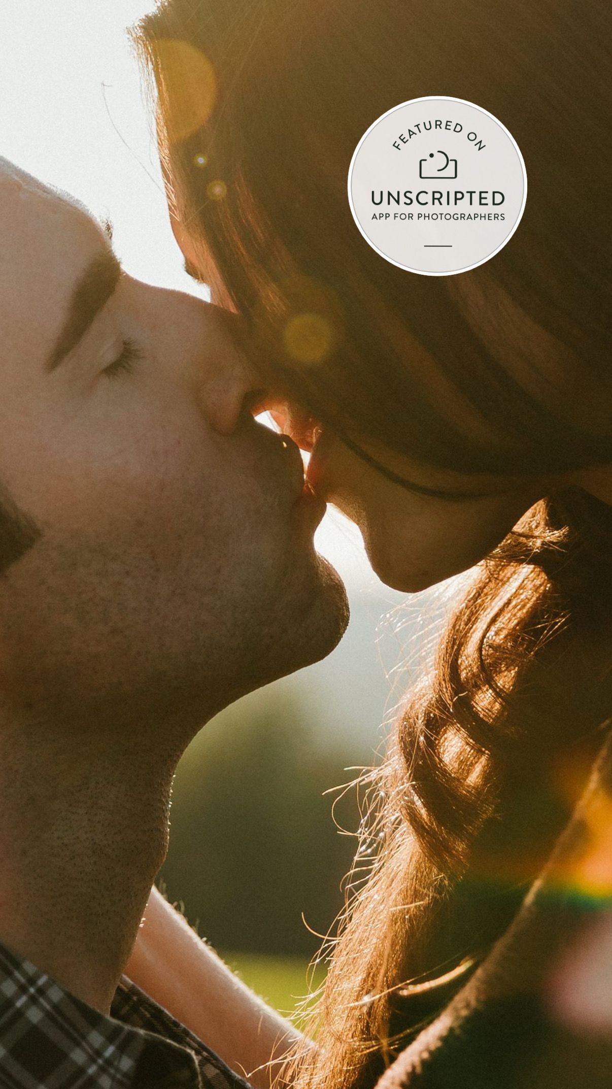 Silhouetted couple sharing an intimate moment in golden sunlight with hair backlit creating a dreamy atmosphere.