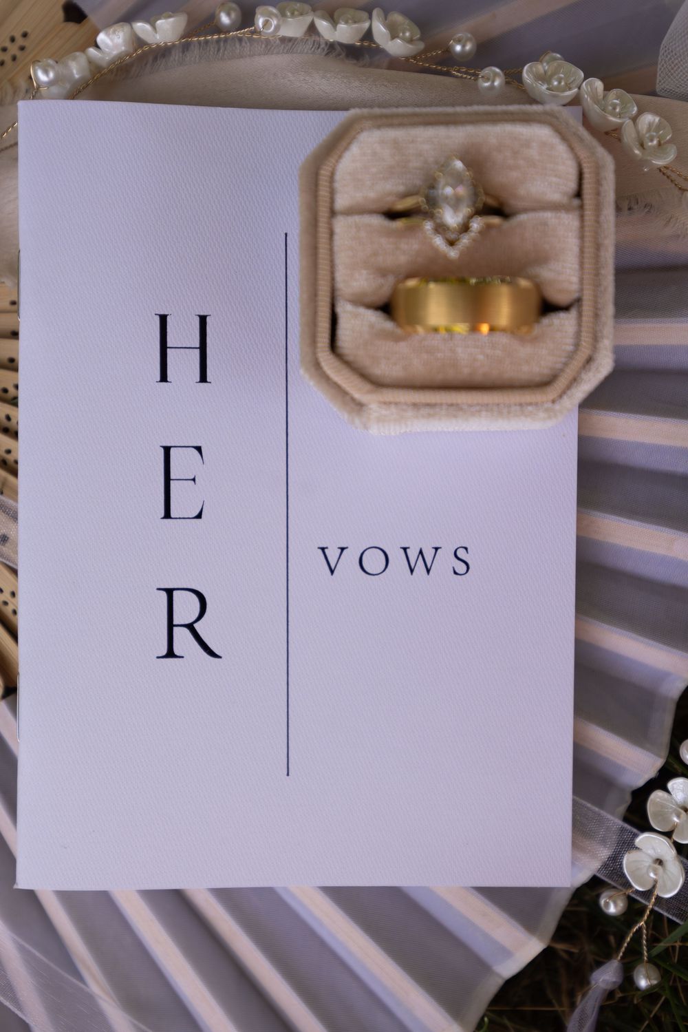 Elegant white wedding vow booklets with minimalist typography featuring the letters 'H' and 'R' on display.
