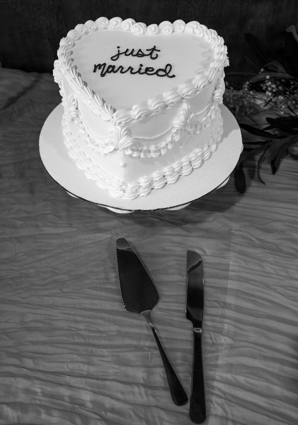 A collage of wedding cakes decorated with white frosting and pearl details shown from different angles on a white tablecloth.
