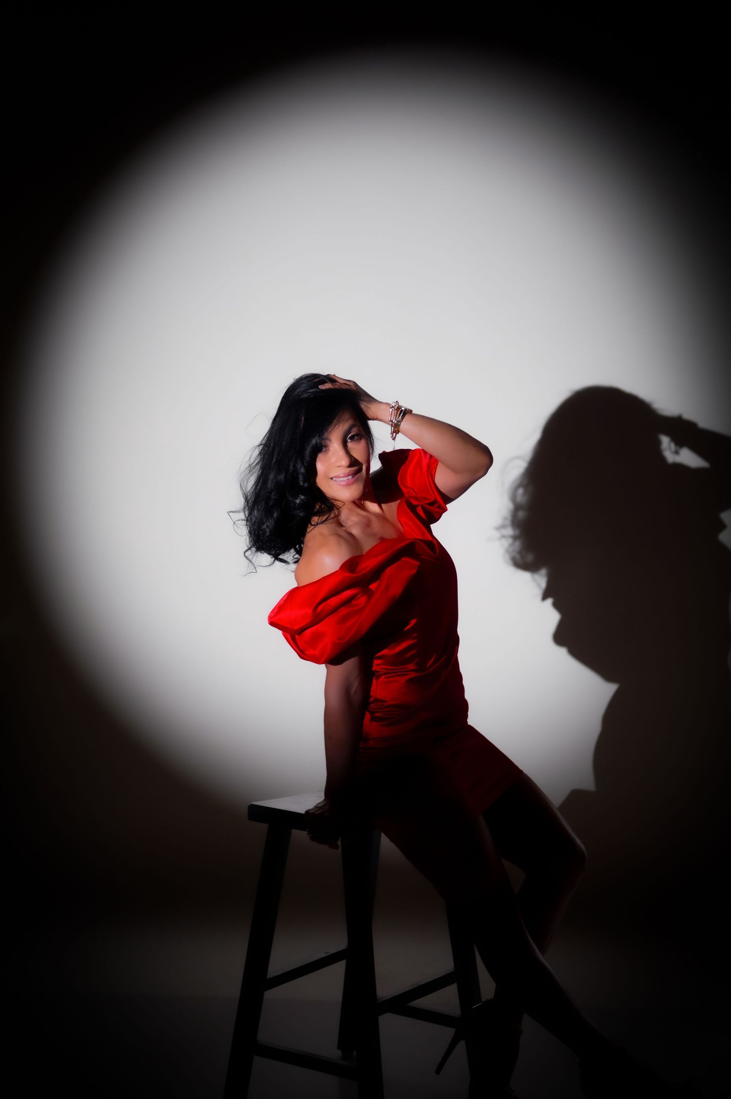 Artistic studio portraits featuring black silk dress against dark atmospheric background.