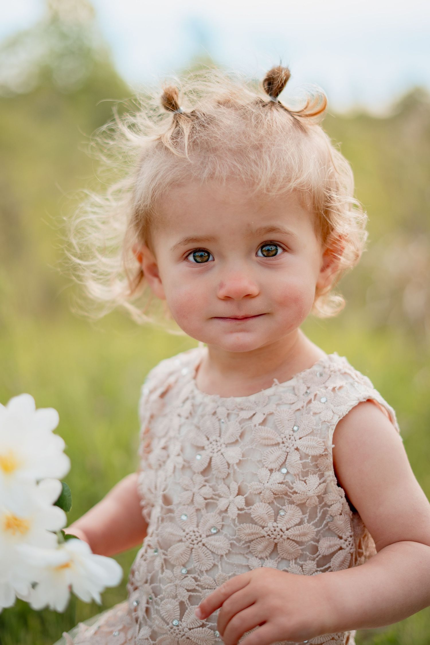 baby in a beautiful dress, enjoying a child photoshoot in a sunny West Michigan field. A perfect moment for Grand Rapids family photography