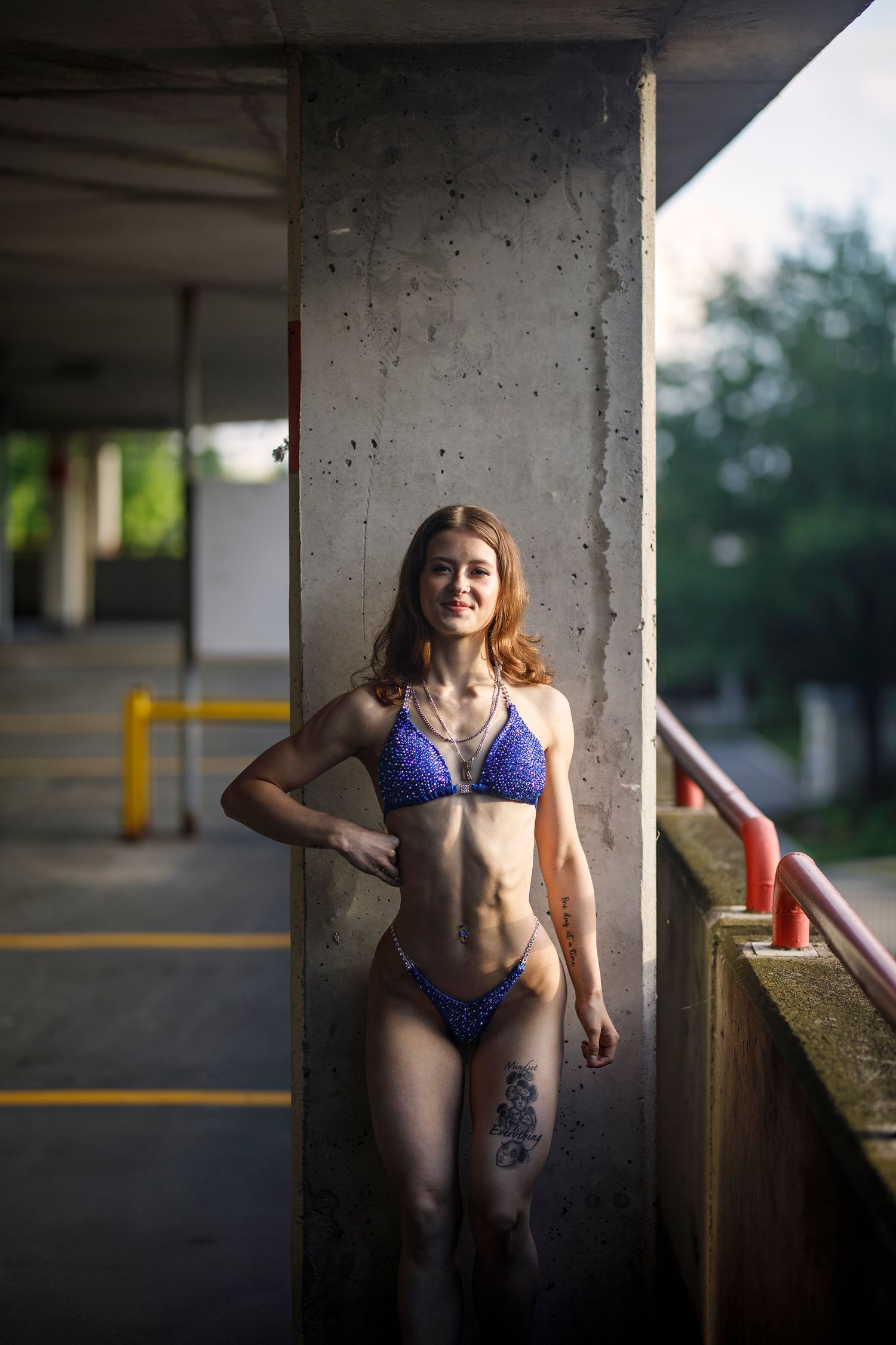Artistic photo sequence showing a person in blue swimwear posing against concrete pillars in a parking garage.