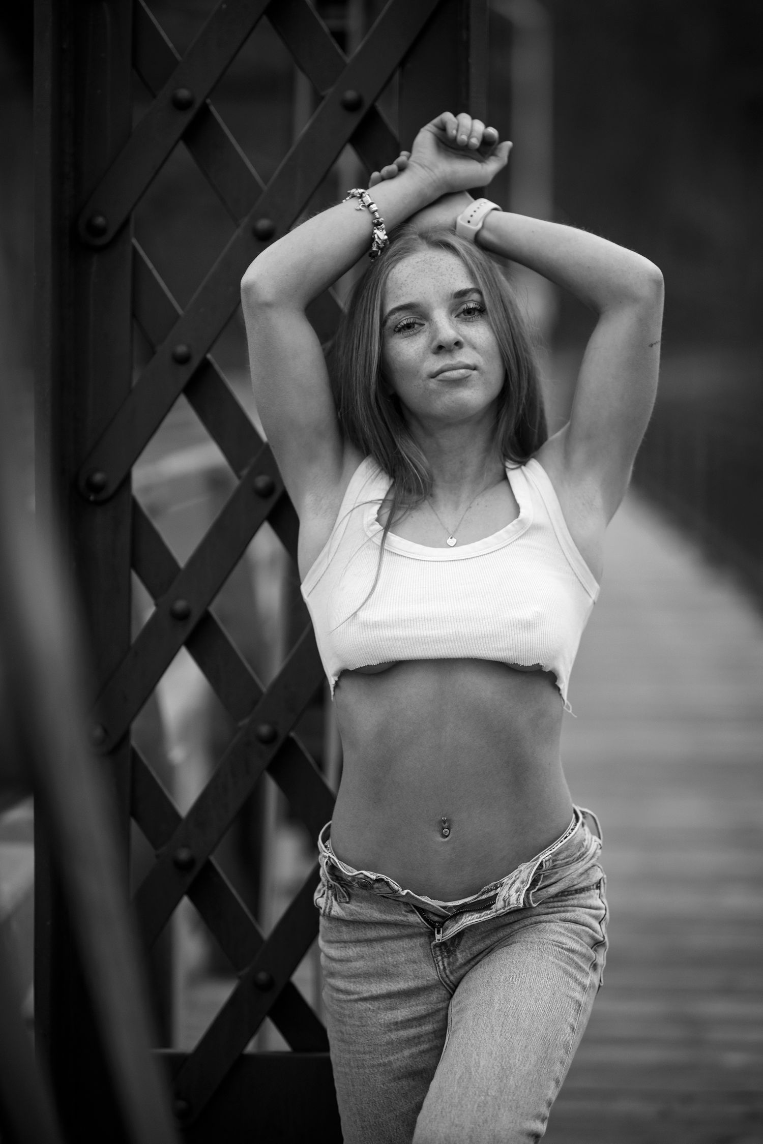 A young dancer appears expressive in black and white against a geometric lattice background.