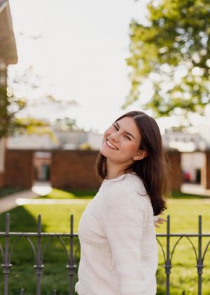 Natural lifestyle portraits with warm sunlight and iron fence backdrop.