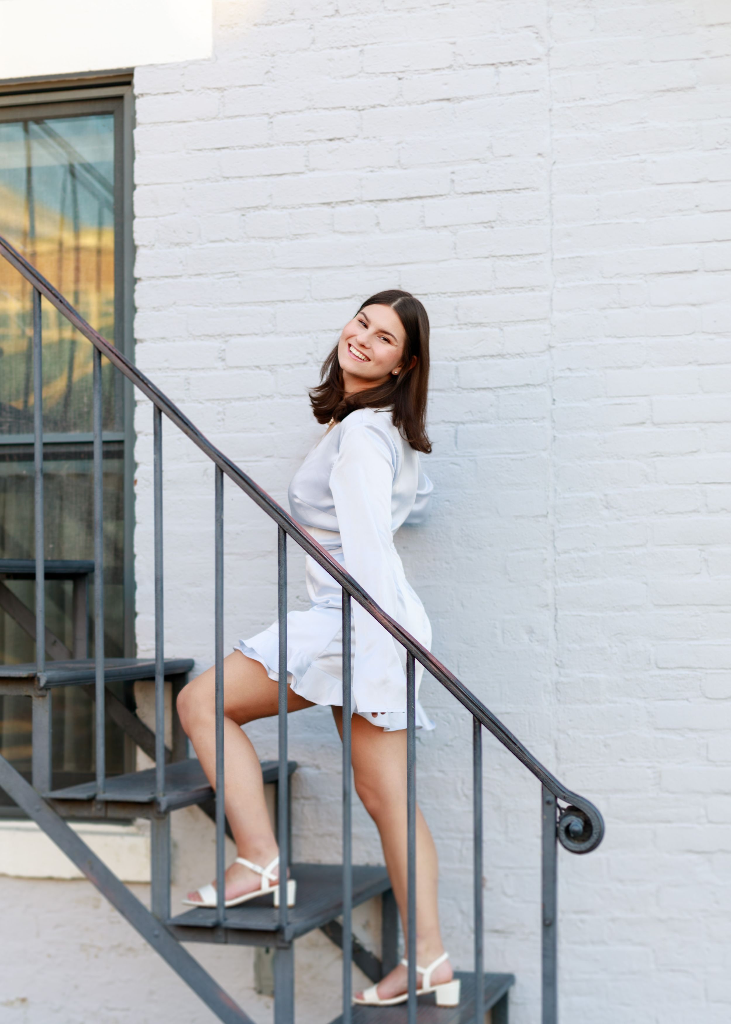 Dynamic poses on white painted stairs showcasing movement and elegance.