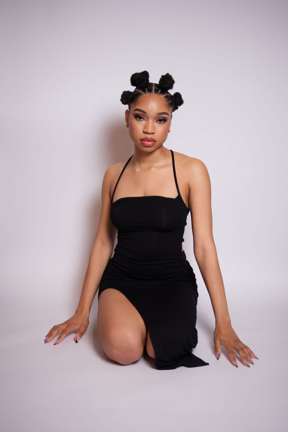 Young lady posing in a studio with a vibrant, creative background in Griffin, Georgia