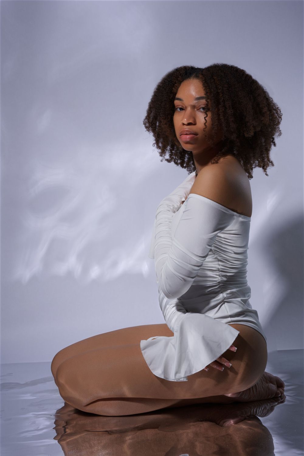 Young lady posing in a studio with a vibrant, creative background in Griffin, Georgia
