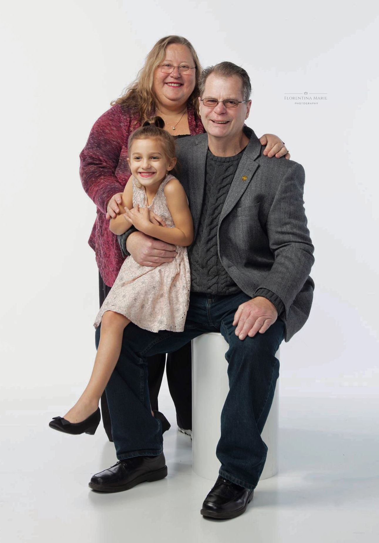 A happy family in a studio portrait against a white background wearing casual attire.