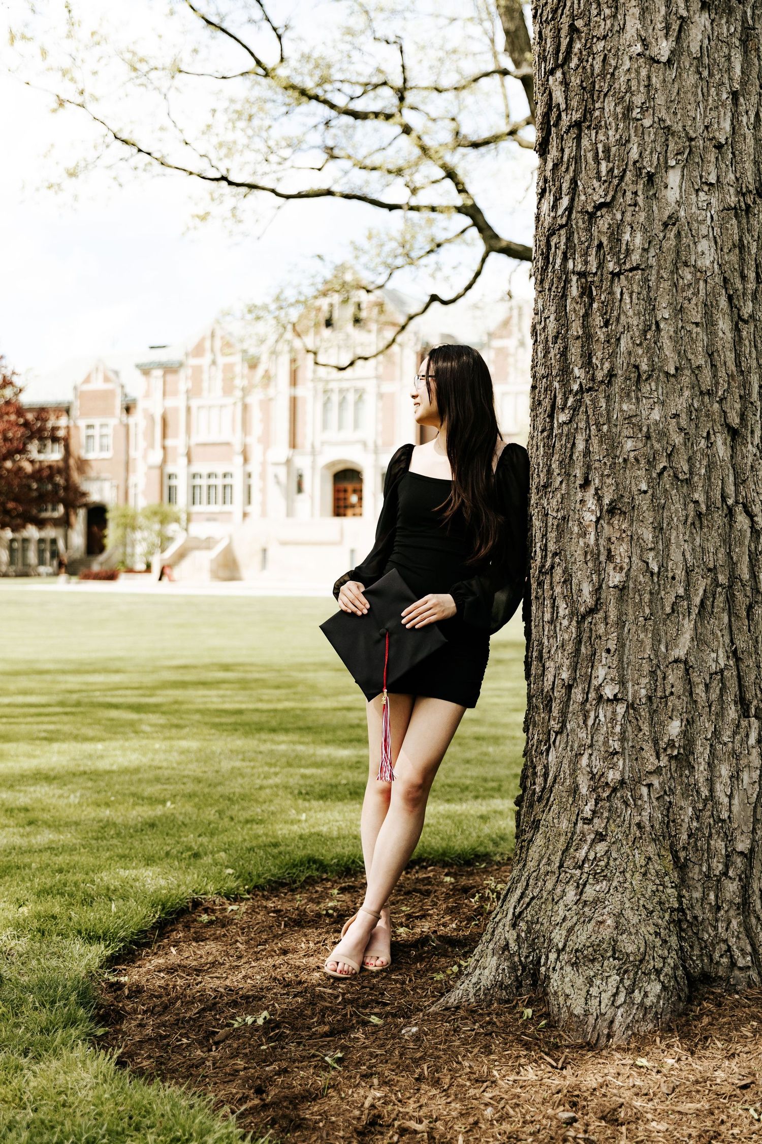 Elegant portrait series captured under large trees on a grassy campus lawn.