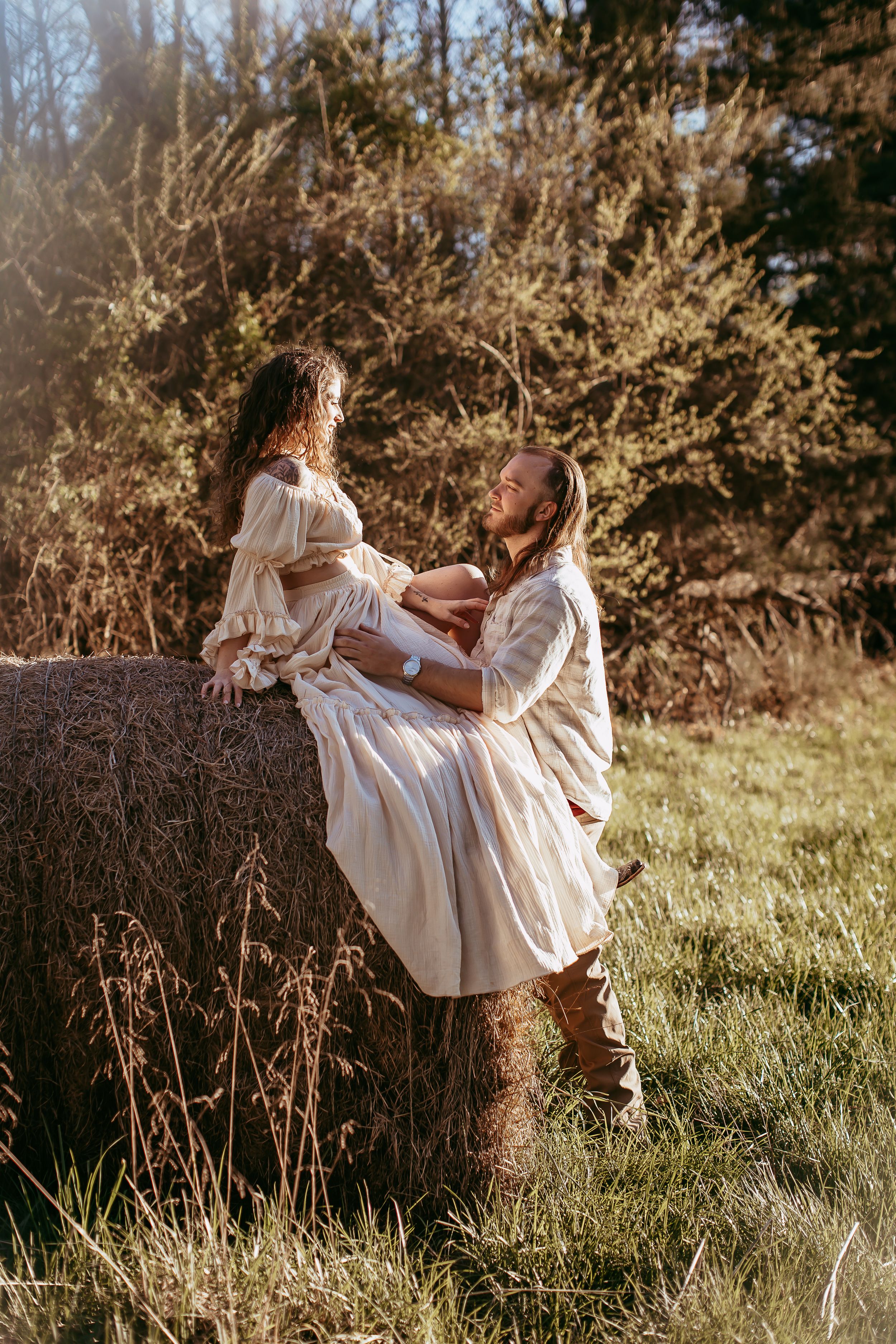 A romantic countryside scene with flowing white dresses in golden sunlight.
