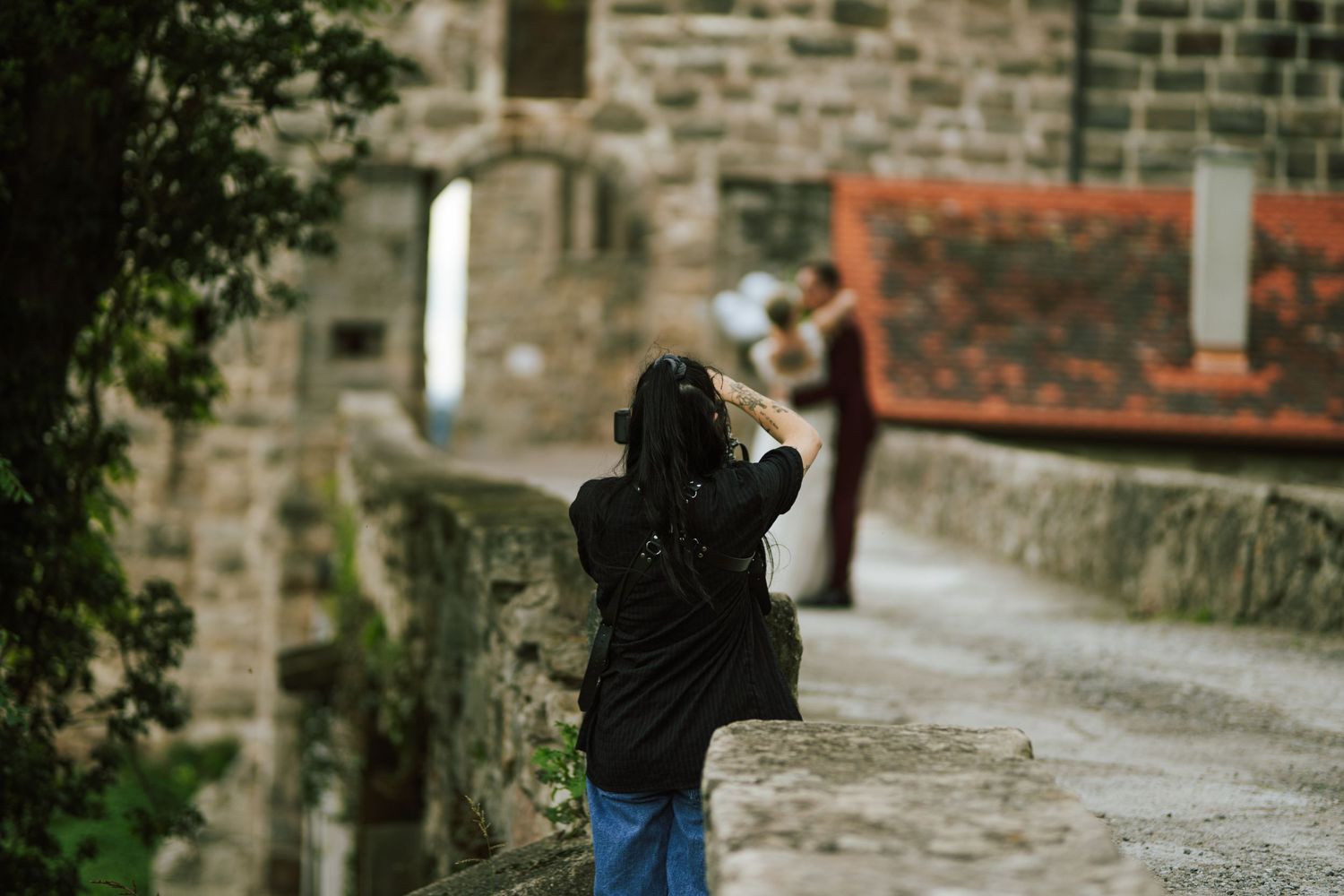 Photographer capturing images on a stone path near historic buildings.