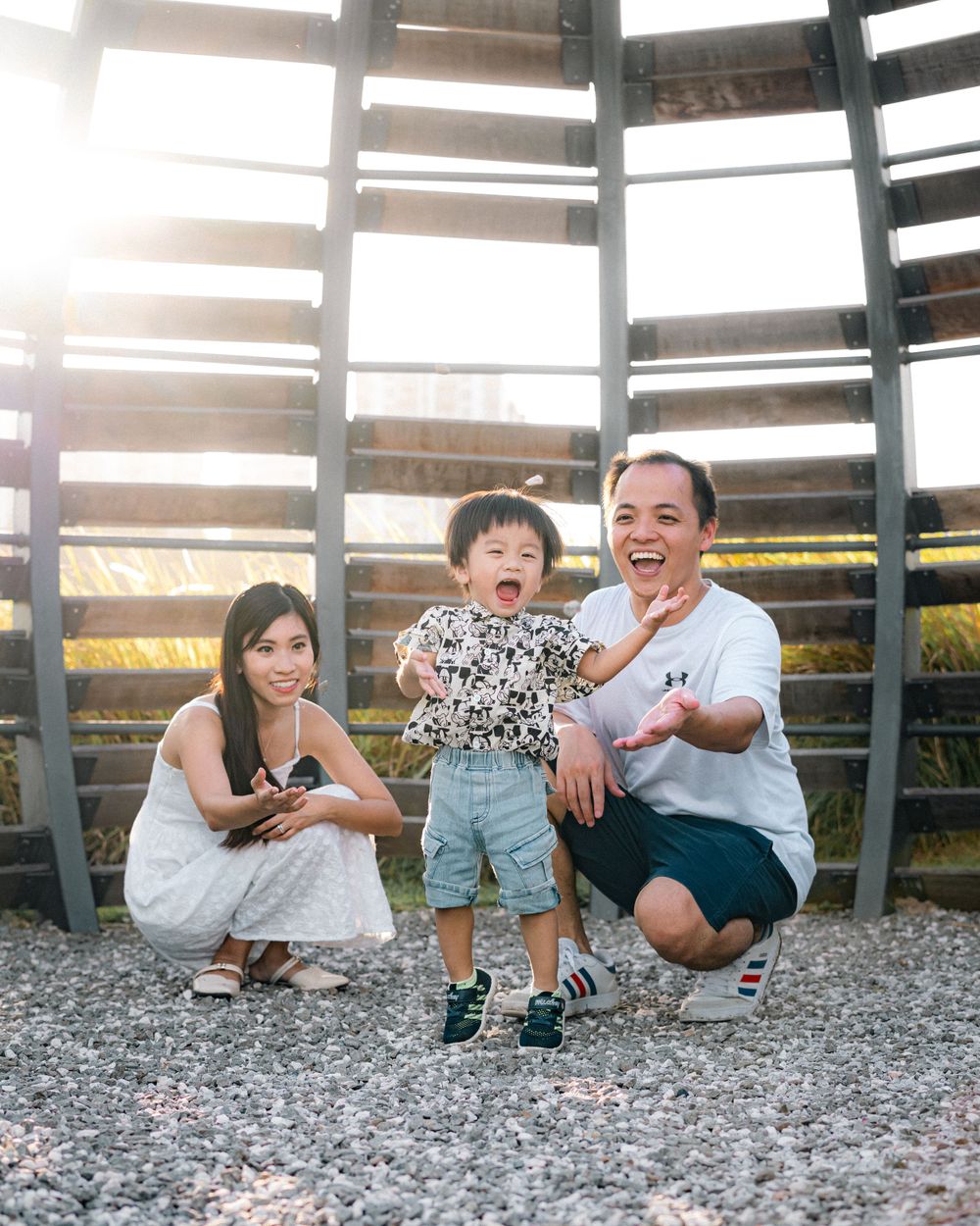 A family shares a joyful moment together in front of a wooden structure during sunset.