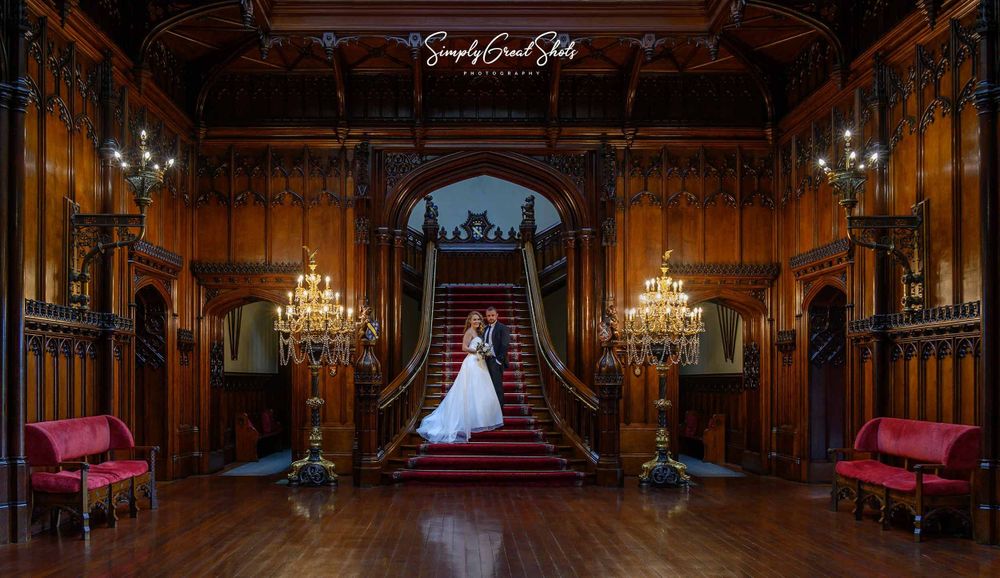 A husband and wife stand on a grand staircase after tying the knot.