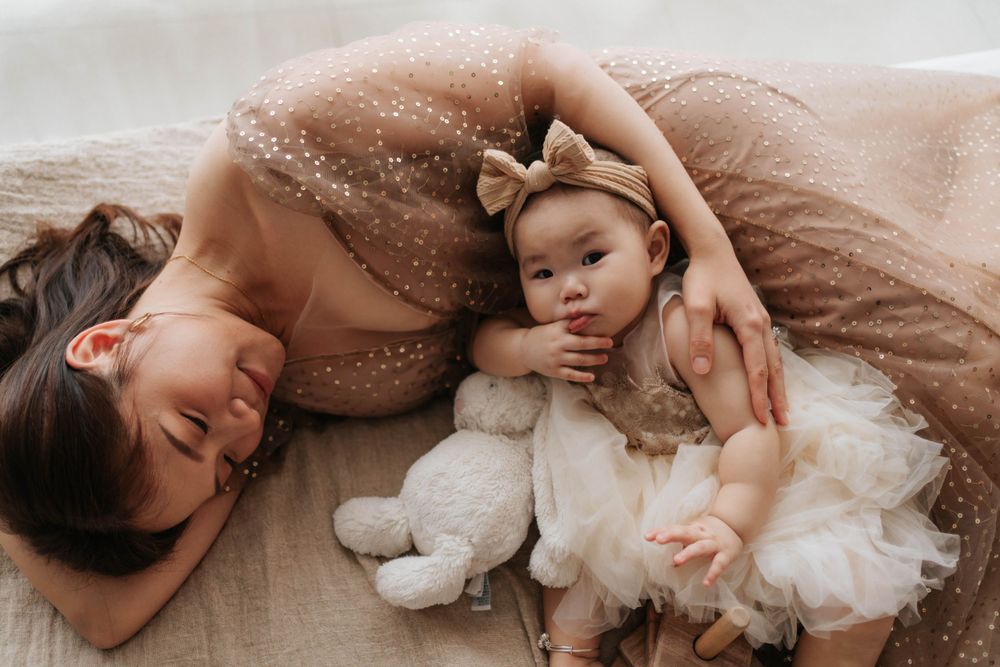 Intimate lifestyle photo on bed with soft neutral tones and glitter effects.