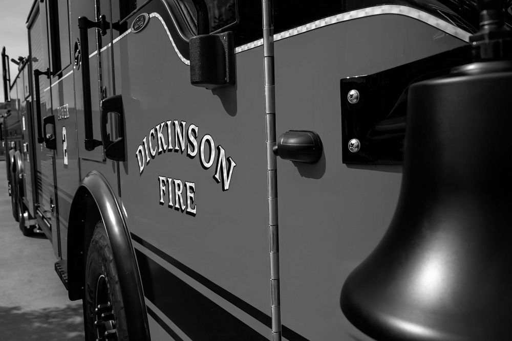Black and white close-up of Dickinson Fire Department lettering on truck.