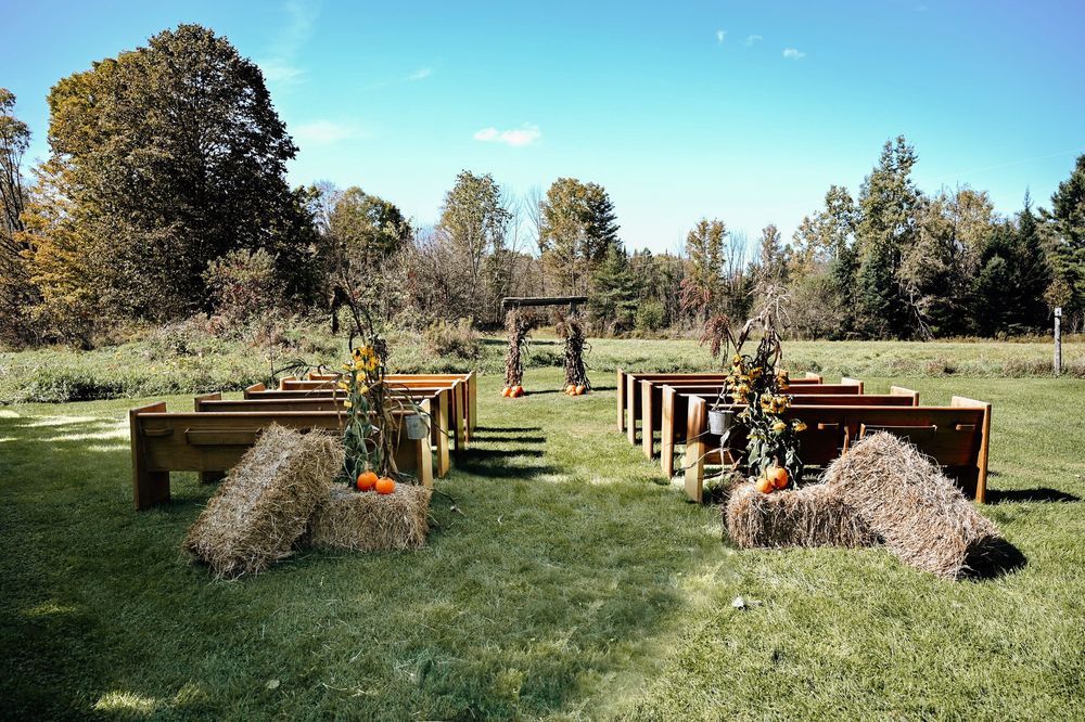 An outdoor equestrian cross country course with wooden jumps and natural obstacles arranged on a grassy field.