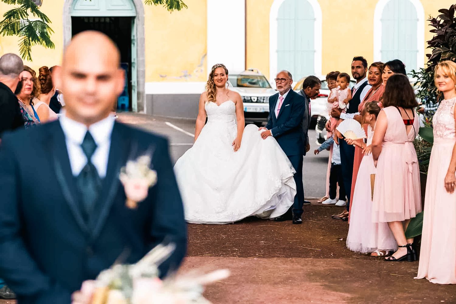 Wedding party gathers outside with bridesmaids in pink dresses as a couple celebrates their special day.