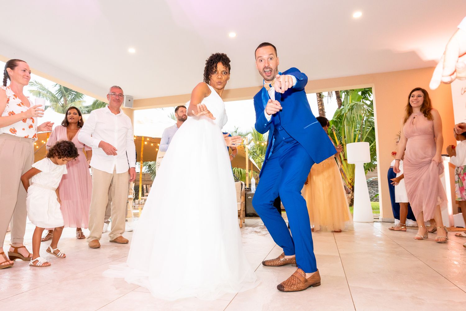 Newlyweds dance and celebrate together at their wedding reception in a bright indoor venue.