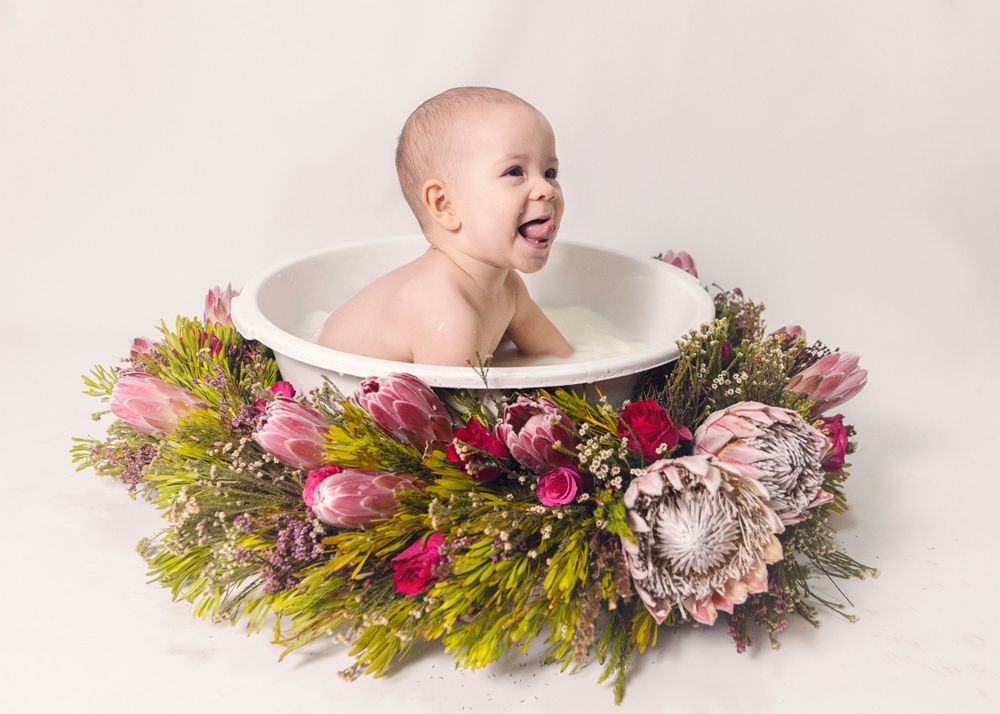 Vibrant bath portrait with colorful protea and greenery arrangement.