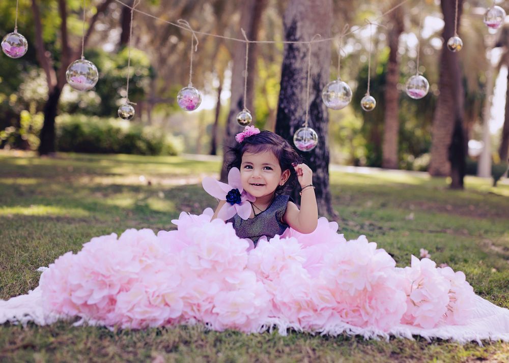 Enchanted forest scene with hanging glass ornaments and fluffy pink tulle dress.
