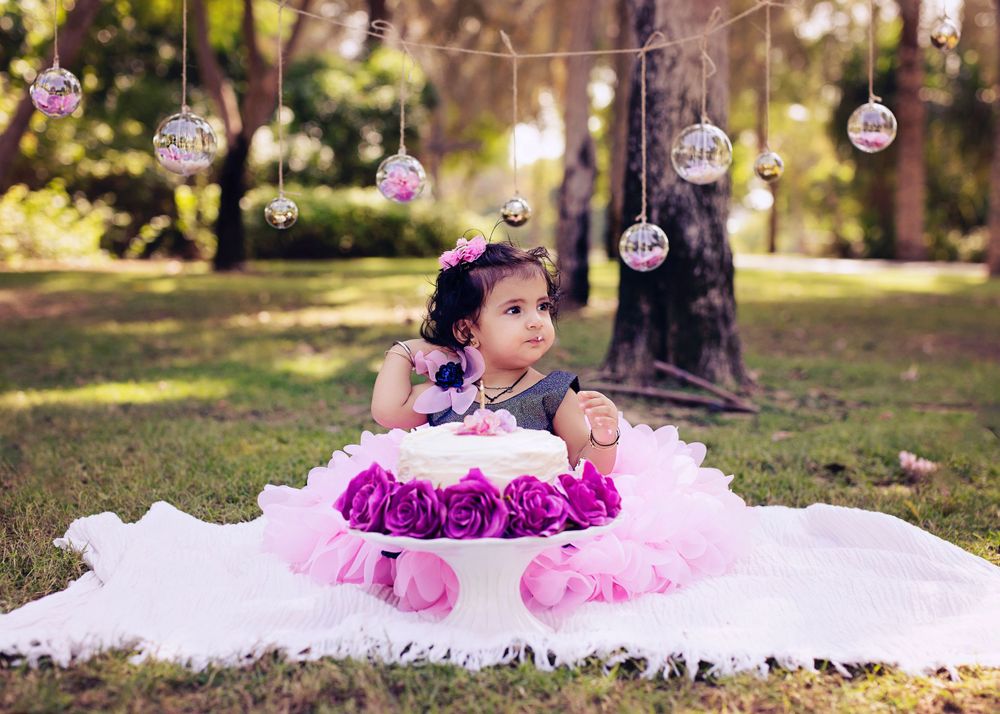Dreamy outdoor setting with hanging glass ornaments and pink floral decorations on white tulle.