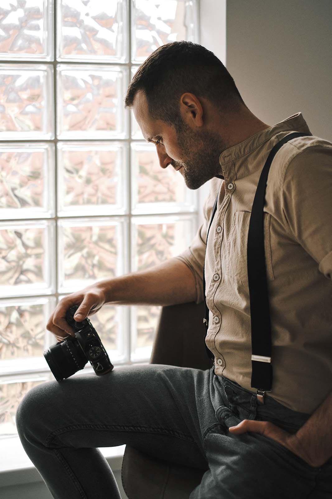 Profesionalni fotograf sedi na stolici sa foto-aparatom u ruci
To je njegov omiljeni aparat marke Fujifilm 
Novi Sad