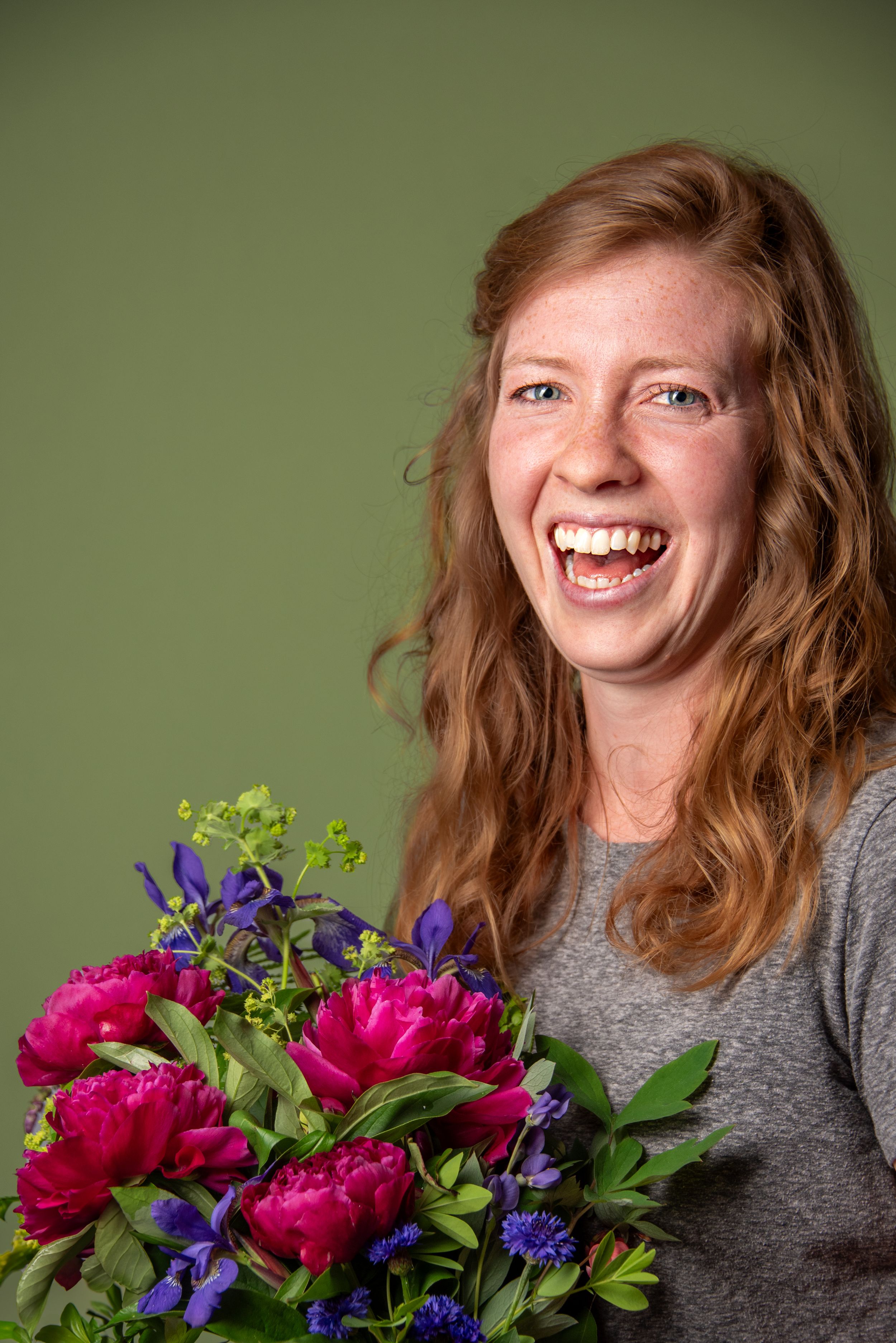 Bouquet of flowers, portrait of woman smiling.